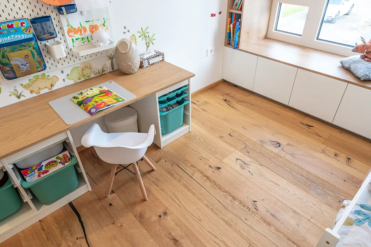 Svetla in igriva otroška soba z lesenimi tlemi, ki so varna in prijetna na dotik